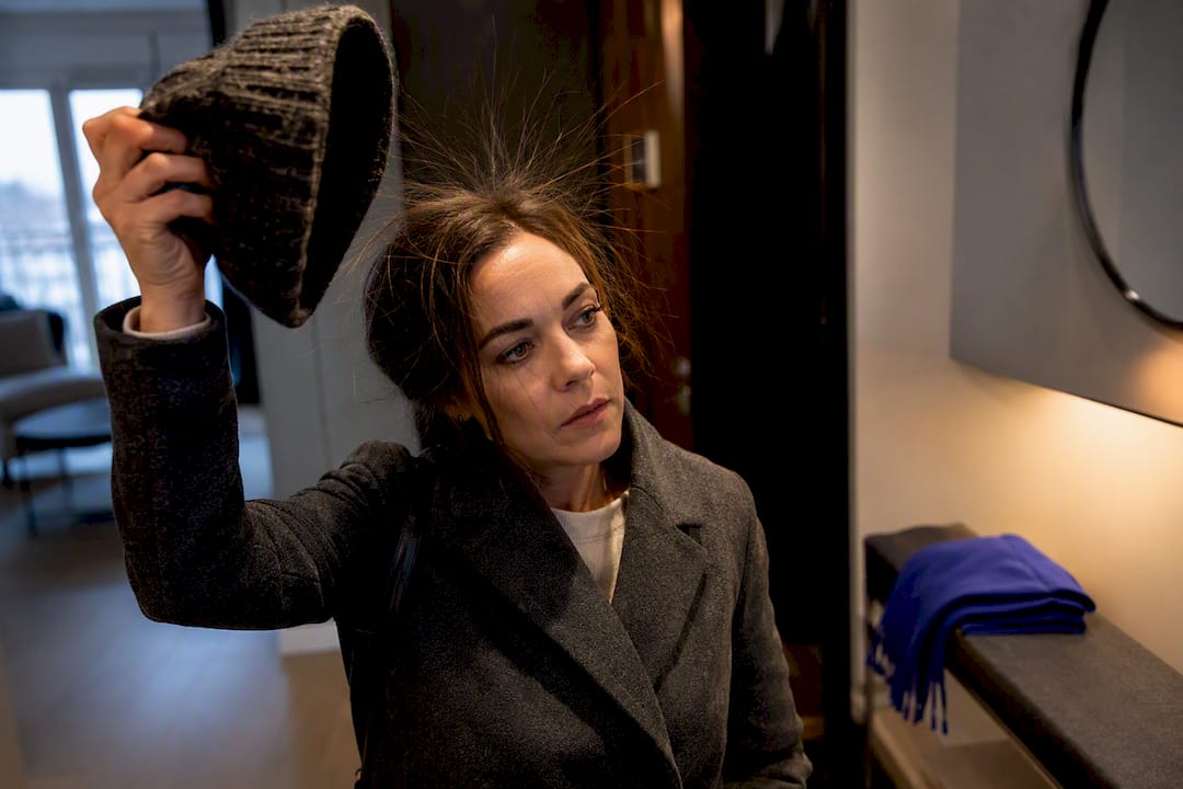 Woman removing beanie with static flyaway hair
