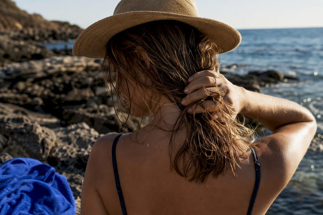 Windblown hair protected at sunny beach