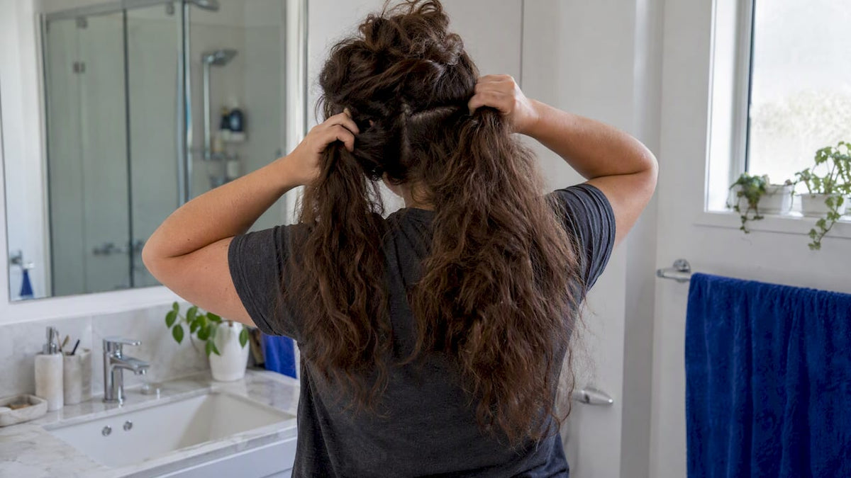 Woman sectioning thick hair before wash day