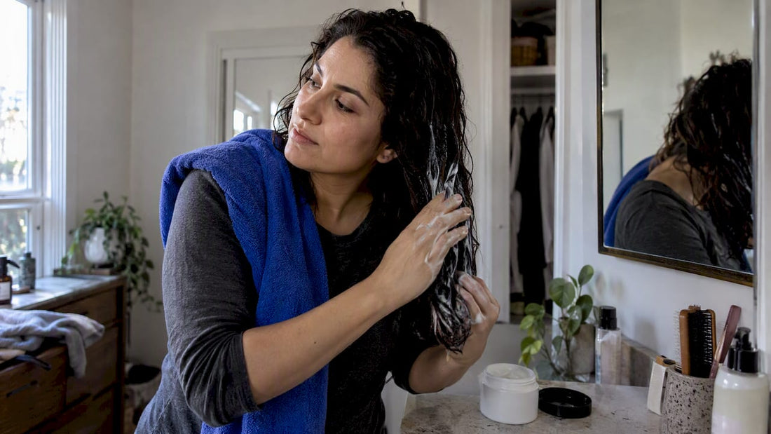 Woman working conditioner through damp hair